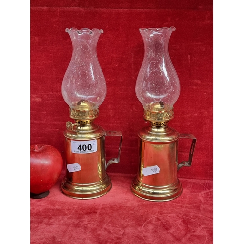 400 - A pretty pair of brass  metal oil lamps with fluted glass chimneys, handles, and pierced galleries.