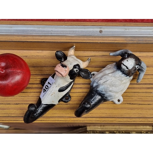 401 - Two whimsical cast metal wall coat hooks in the form of a bull and a ram.