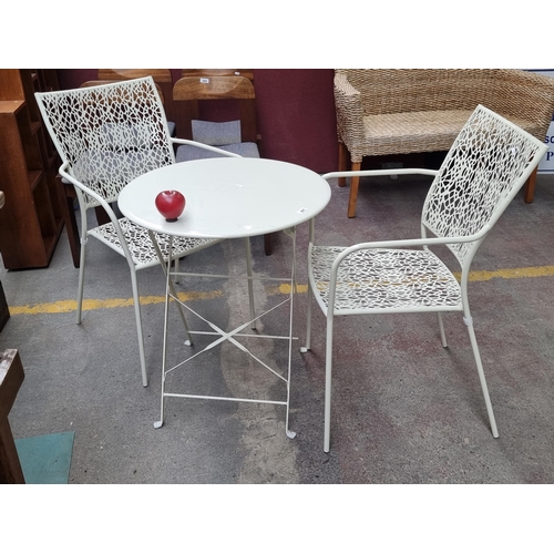 447 - A stylish garden set including a round folding table and a pair of chairs with an unusual abstract c... 