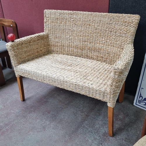 449 - A charming rattan two-seater sofa with curved armrests and wooden legs.