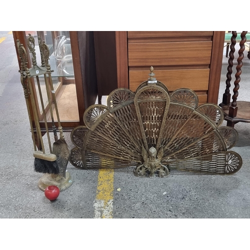 672 - Two antique elegant brass fire side items including a peacock fire screen with foldaway panels and a... 