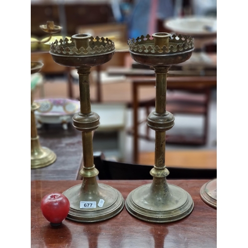 677 - A pair of 19th century brass ecclesiastical candle holders with trefoil trim to drip tray and turned... 