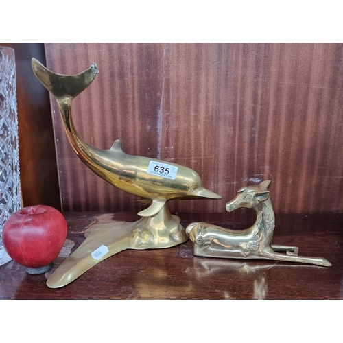 635 - Two figural brass sculptures. Including a reposing fawn and a diving dolphin figure.