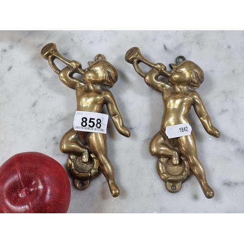 858 - A pair of ornate heavy vintage brass door knockers in the form of cherubs playing trumpets. With bra... 