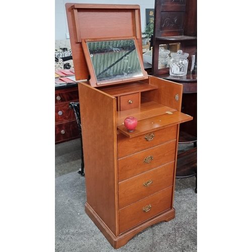 866 - A tallboy with five drawers with brass drop pull handles. The top lifts up to reveal a Mirror and sp... 