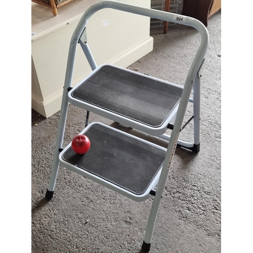 904 - A steel two-step ladder with rubberised steps for extra grip, in a grey finish.