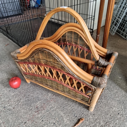 913 - A beautiful example of a wicker magazine rack with two compartments, curved handle and edges, and a ... 