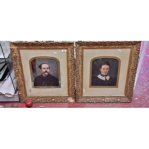 99 - Star Lot : Two ornate antique gilt frames holding a twin portraits of a gentleman and his wife in so... 