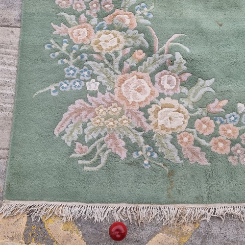 947 - Star Lot : A very  large low pile rug in a mint green with floral border. Mm: 380 x 271 cm