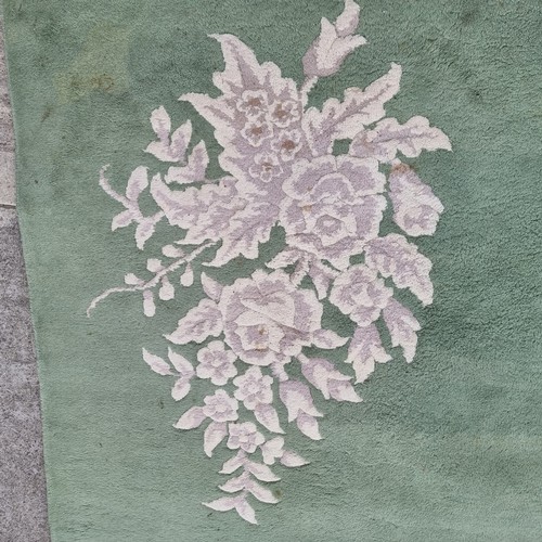 947 - Star Lot : A very  large low pile rug in a mint green with floral border. Mm: 380 x 271 cm