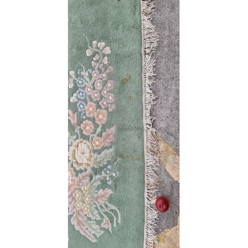 947 - Star Lot : A very  large low pile rug in a mint green with floral border. Mm: 380 x 271 cm