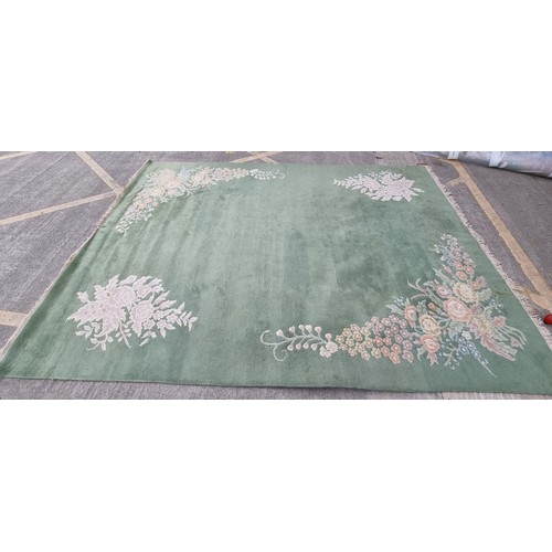 947 - Star Lot : A very  large low pile rug in a mint green with floral border. Mm: 380 x 271 cm