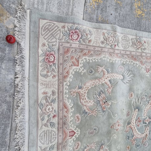 948 - A very large Chinese wool on cotton low pile rug in a mint green with dragon ornament throughout. Mm... 