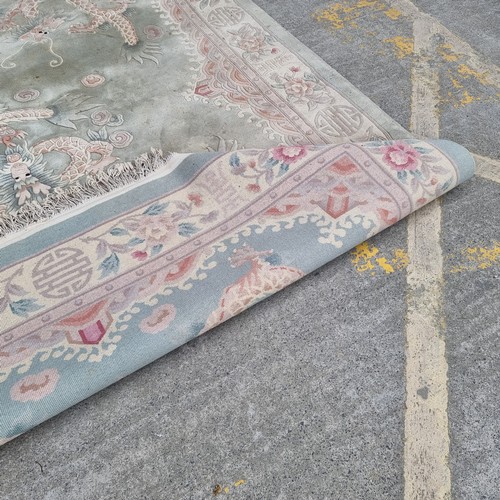 948 - A very large Chinese wool on cotton low pile rug in a mint green with dragon ornament throughout. Mm... 