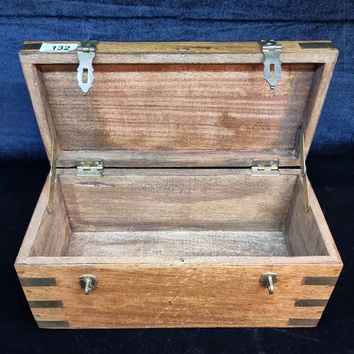 132 - A heavy wooden chest with brass edging and reinforcements and handles to side.