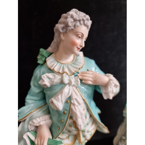 168 - Two vintage German bisque figures in 18th century dress in shades of turquoise and gilt. Stamped AM ... 