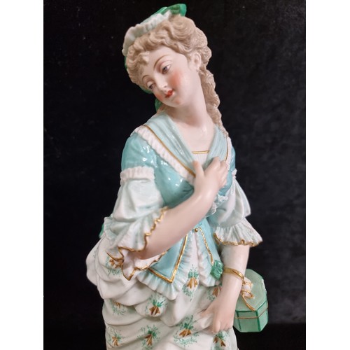 168 - Two vintage German bisque figures in 18th century dress in shades of turquoise and gilt. Stamped AM ... 