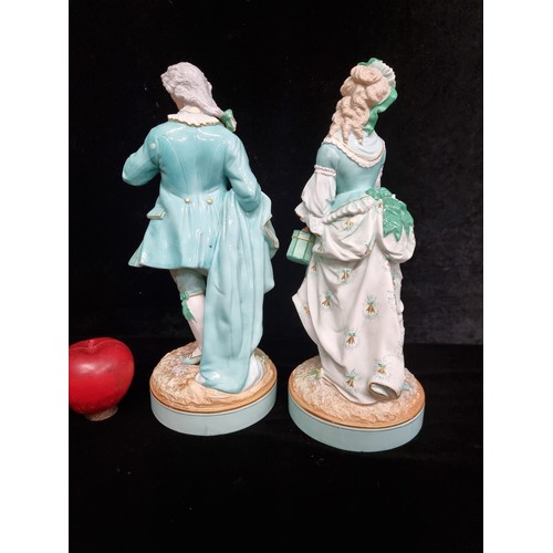 168 - Two vintage German bisque figures in 18th century dress in shades of turquoise and gilt. Stamped AM ... 