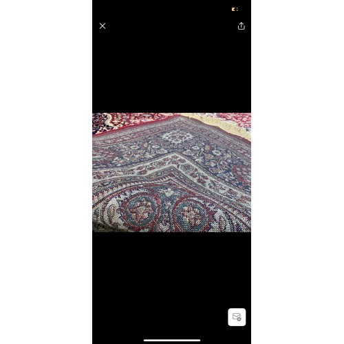 923 - Star lot : A large elegant wool rug with a rich floral design in jewel tones of red and blue accentu... 