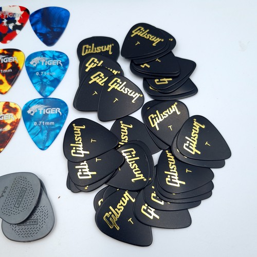 7 - A Gibson metal case, containing a large and assorted quantity of Gibson guitar picks. Great collecti... 