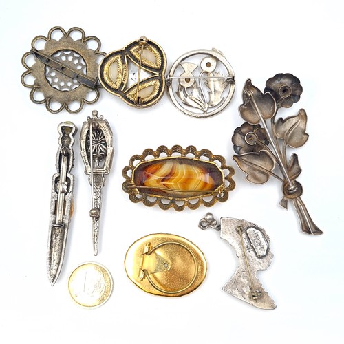 60 - A collection of nine items, including an attractive and well formed African silver pendant/brooch wh... 