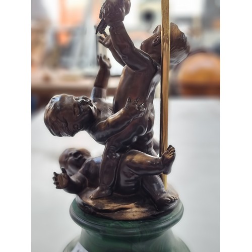 189 - A tall and striking table lamp with three chubby cherubs frolicking on the base topped with a tassle... 