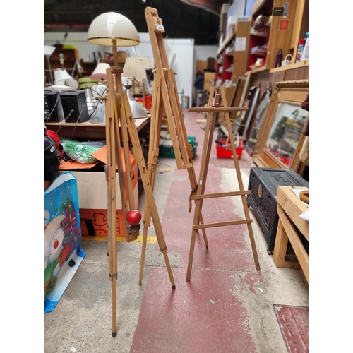 Two adjustable artist's easels. Designed in beechwood with brass hardware.