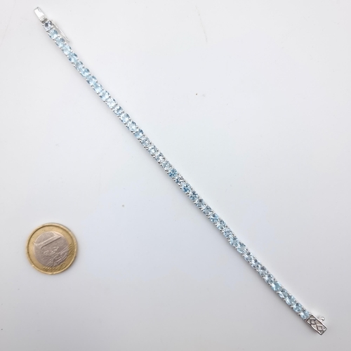 609 - Star Lot : A stunning natural Blue Topaz  tennis bracelet, set in Sterling Silver. Beautiful item on... 