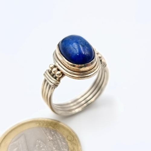 637 - A very attractive sterling silver Lapis Lazuli stone ring, set with a roped four strand channel cut ... 