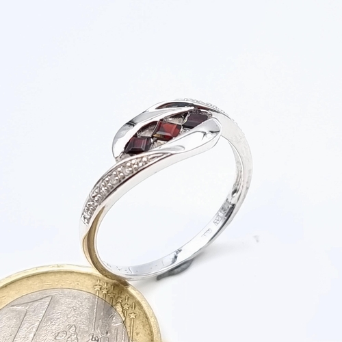 651 - Star Lot : A beautiful 9 carat White Gold three stone Garnet ring, set with White Sapphire shoulders... 