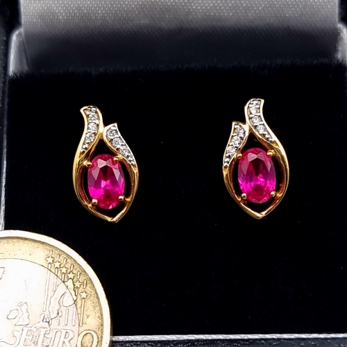 653 - A pair of natural Ruby and Sapphire 9 carat gold plated stud earrings. Old, new boxed stock.