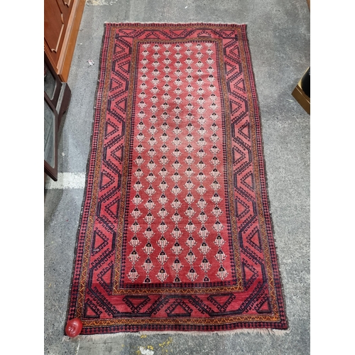 666 - Star lot : A fabulous hand knotted woollen floor rug / runner with  a red ground and cream and black... 