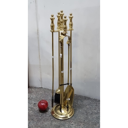 672 - A heavy brass  brass fireside companion stand including four tools such as a poker, tongs, shovel an... 