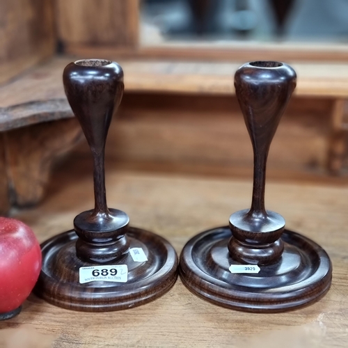 689 - A beautiful pair of antique carved wooden candle sticks with lovely turned detail to stems and round... 