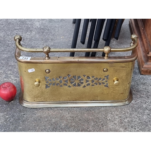 733 - A neat sized polished brass fire fender with pierced floral design. H26cm x L48cm