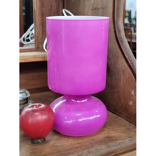 734 - A retro style LYTKA table lamp. Designed entirely in a magenta clad milk glass with an integrated cy... 