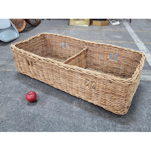 742 - A large wicker basket with handles to side and two interior compartments.