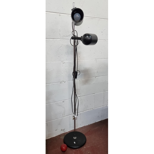 755 - A stylish floor standing lamp with two adjustable light fittings held on a heavy circular base. Set ... 