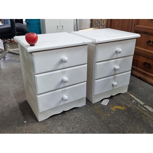 801 - A pair of pine wood bedside lockers in a contemporary cream finish. Sporting three drawers each.