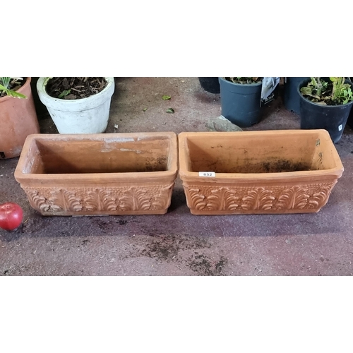 852 - A pair of terracotta box planters with acanthus leaf motif to side.