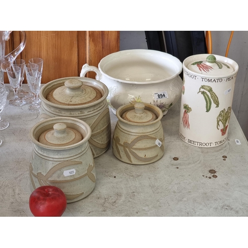 894 - Five ceramic kitchen items including a set of three graduating lidded stoneware jars, a taller lidde... 