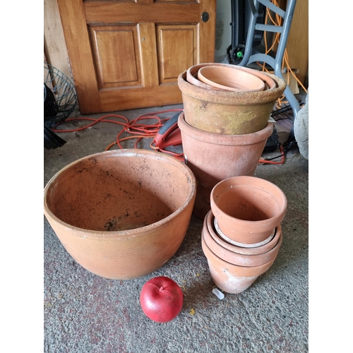 899 - Ten terracotta planters with drainage holes in various sizes including the smallest example H9cm and... 