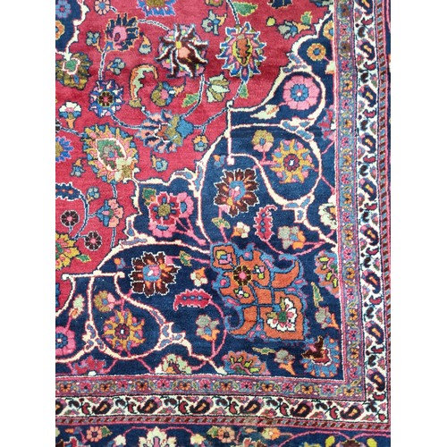 744 - Star lot : A beautiful very large hand knotted woolen Persian rug in shades of cerise and blue with ... 