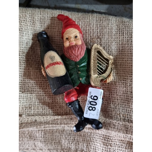 908 - Two Guinness branded items including a characterful seated gnome figure cheerfully perched holding a... 