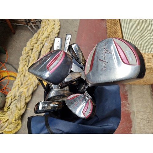 946 - A Maxfli golf  bag holding a large variety of golf clubs by Wilson including three high launch drive... 