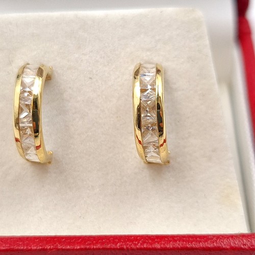 16 - A lovely pair of 9 carat gold hooped stud earrings, featuring pretty gem stone settings. Encased in ... 