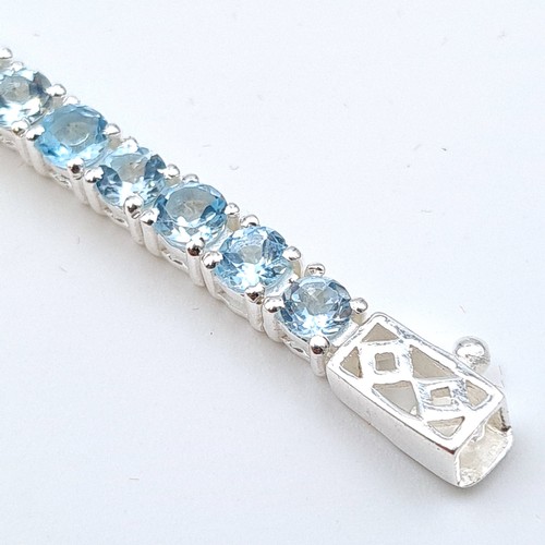 609 - Star Lot : A stunning natural Blue Topaz  tennis bracelet, set in Sterling Silver. Beautiful item on... 