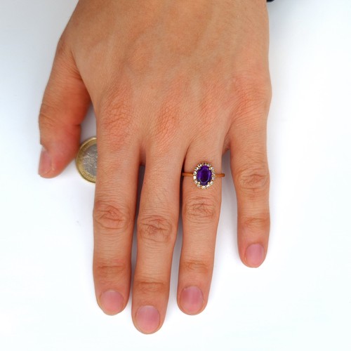 652 - Star Lot : A fine example of a 9 carat gold ring, which features an Amethyst central stone and surro... 