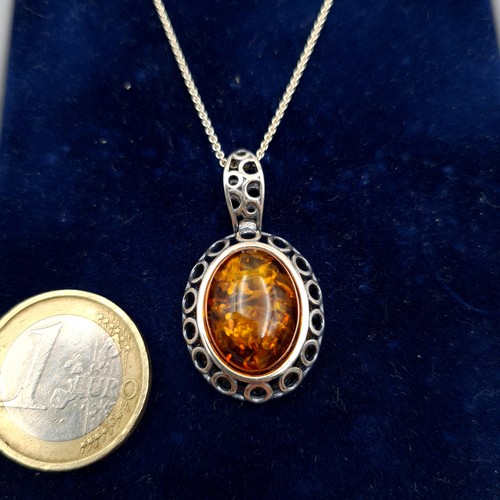 638 - A lovely Baltic fire Amber sterling silver pendant and chain, this necklace features a intricate cir... 