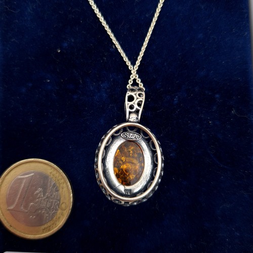 638 - A lovely Baltic fire Amber sterling silver pendant and chain, this necklace features a intricate cir... 